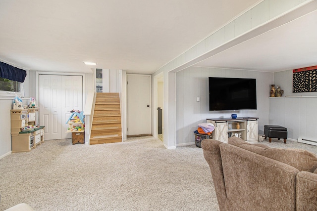 carpeted living area with stairs and baseboards