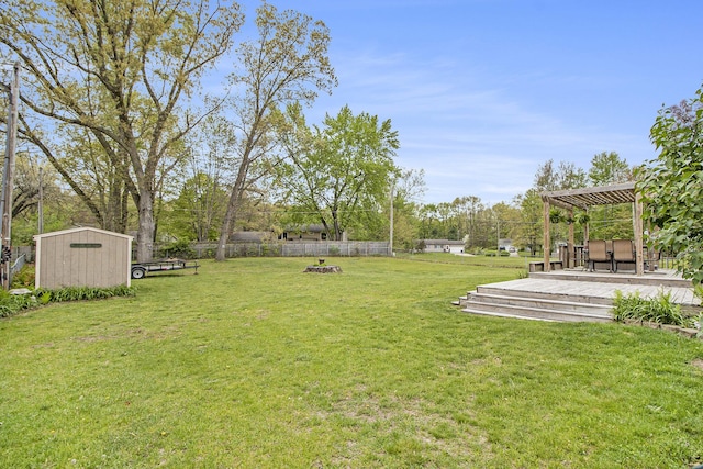 view of yard featuring a deck, a storage unit, an outbuilding, and a pergola