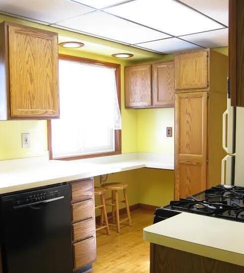 kitchen with black appliances, light countertops, and light wood-type flooring