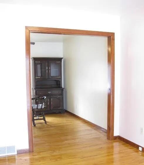 hall featuring light wood-style floors and baseboards