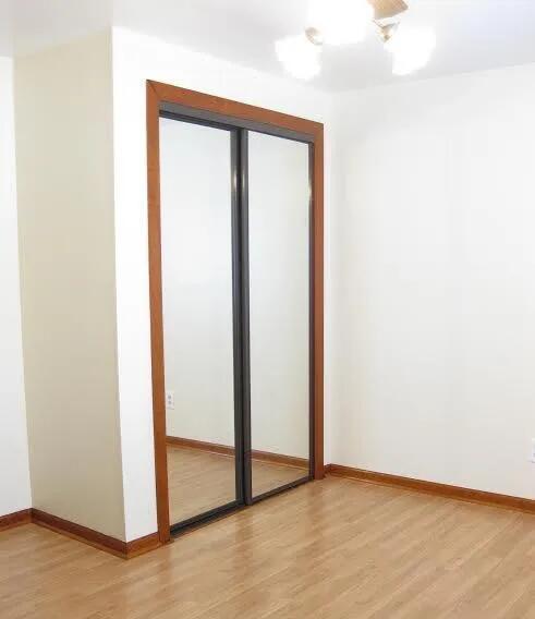 unfurnished bedroom with light wood-style flooring, baseboards, and a closet
