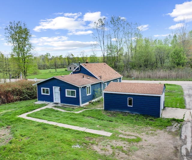 24108 Martinsville Rd, Belleville, MI 48111 - rear view of house with an outdoor structure, a lawn, and a shingled roof
