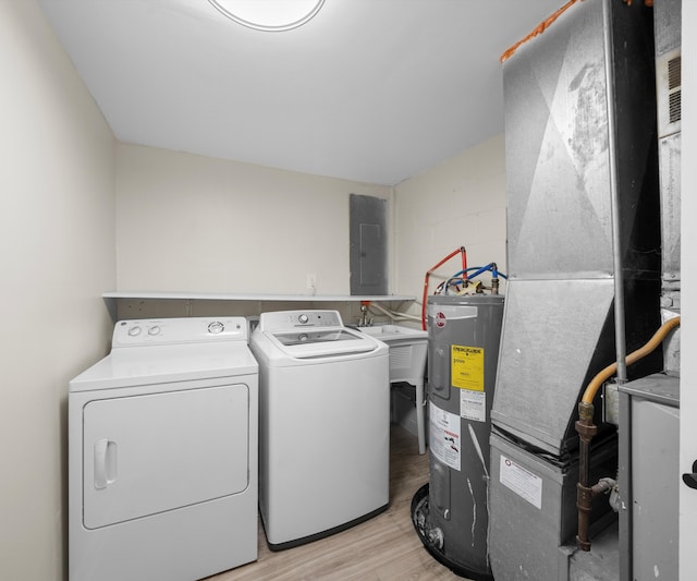 24108 Martinsville Rd, Belleville, MI 48111 - clothes washing area featuring electric water heater, independent washer and dryer, light wood-style flooring, heating unit, and electric panel