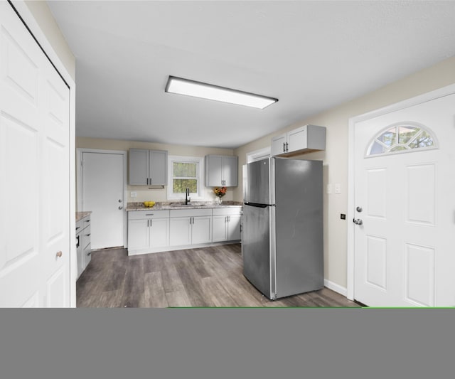 24108 Martinsville Rd, Belleville, MI 48111 - kitchen with freestanding refrigerator, a sink, dark wood-type flooring, gray cabinetry, and light stone counters