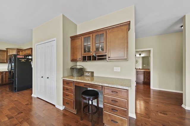 510 Edward J St, Clinton, MI 49236 - kitchen with freestanding refrigerator, dark wood-style flooring, brown cabinets, and glass insert cabinets
