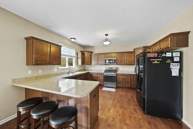 510 Edward J St, Clinton, MI 49236 - kitchen with appliances with stainless steel finishes, a sink, a peninsula, light countertops, and dark wood-style floors