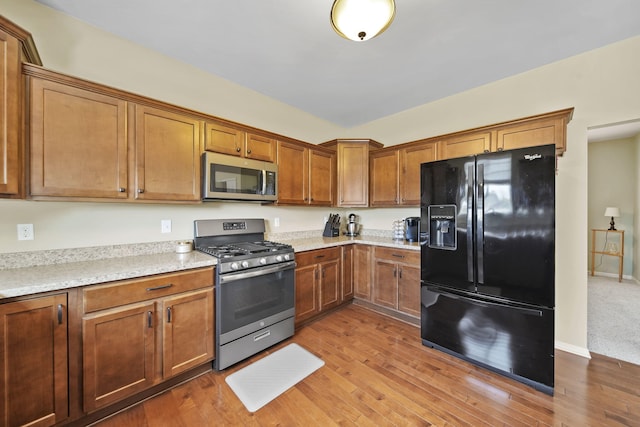 510 Edward J St, Clinton, MI 49236 - kitchen featuring appliances with stainless steel finishes, brown cabinets, and wood finished floors