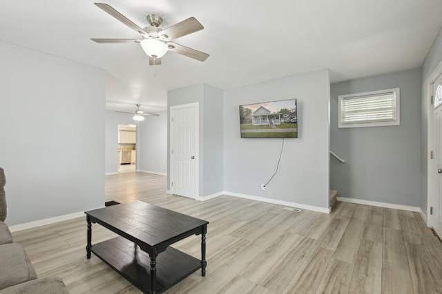 602 Ada Ave, Muskegon, MI 49442 - living room with ceiling fan, light wood-type flooring, baseboards, and stairs