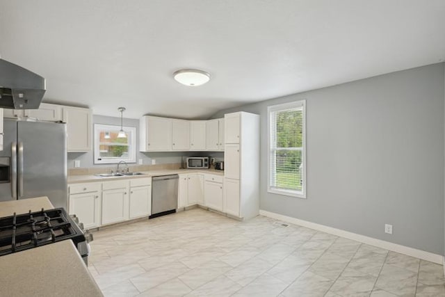 602 Ada Ave, Muskegon, MI 49442 - kitchen with stainless steel appliances, a sink, light countertops, light marble finish floors, and healthy amount of natural light