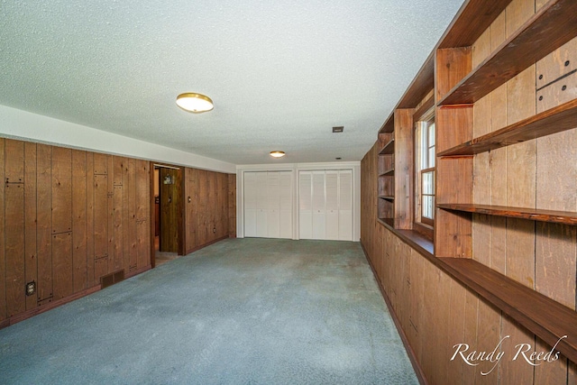 12498 Daling Ct NW, Grand Rapids, MI 49534 - hall featuring wooden walls, a textured ceiling, and carpet floors