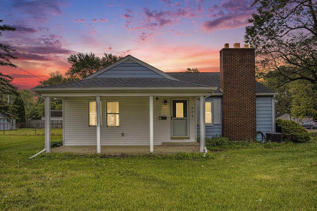 bungalow with a chimney, cooling unit, roof with shingles, and covered porch