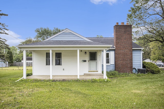 view of front of property featuring a chimney, central AC unit, roof with shingles, and a porch