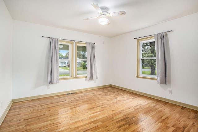 unfurnished room with light wood-type flooring, ceiling fan, and baseboards