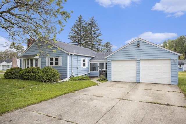 view of front of property featuring driveway, a front lawn, a chimney, an attached garage, and a shingled roof
