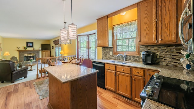 kitchen featuring a sink, black dishwasher, a center island, decorative backsplash, and open floor plan