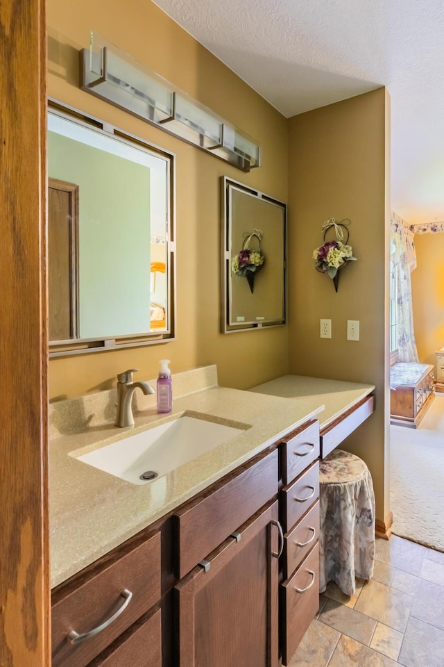 bathroom featuring vanity, a textured ceiling, and stone finish flooring