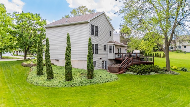 view of side of home with a deck, a yard, and stairs