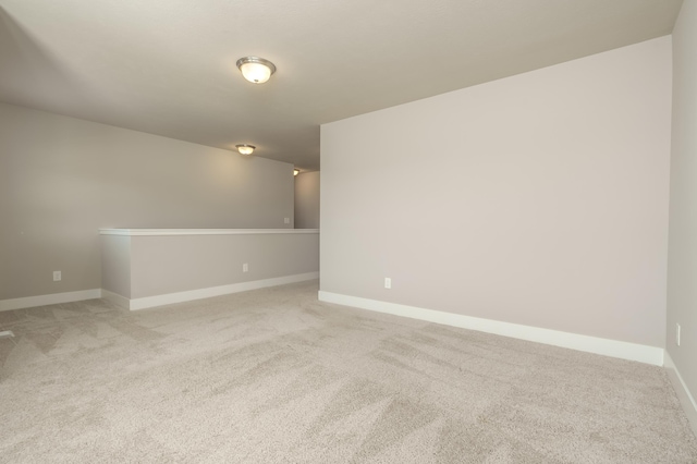 empty room featuring light colored carpet and baseboards