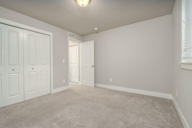 unfurnished bedroom with carpet flooring, baseboards, and a closet