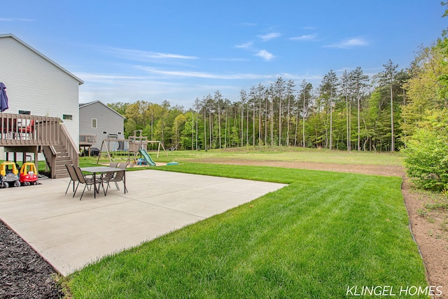 12745 Riverton Rd, Grand Haven, MI 49417 - view of grassy yard with a playground, stairway, a patio area, a deck, and a view of trees