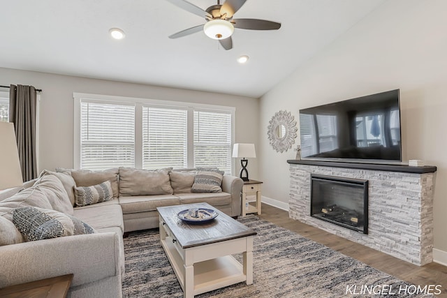 12745 Riverton Rd, Grand Haven, MI 49417 - living room with a ceiling fan, lofted ceiling, wood finished floors, baseboards, and a stone fireplace