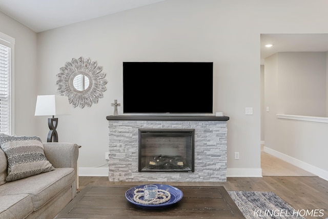 12745 Riverton Rd, Grand Haven, MI 49417 - living area featuring wood finished floors, baseboards, a stone fireplace, and recessed lighting