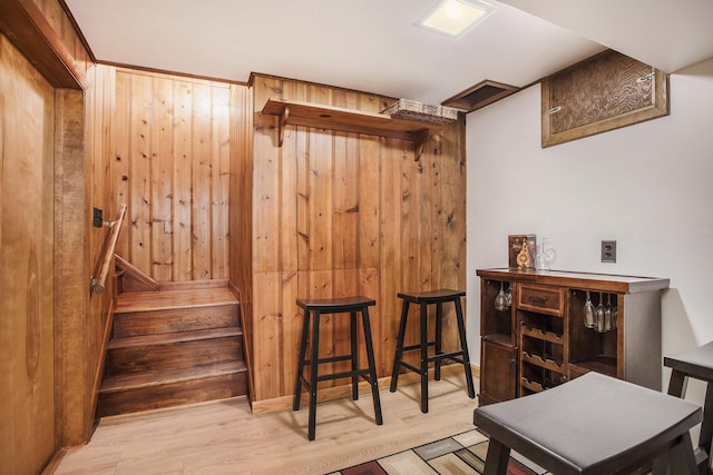interior space with wood finished floors, wooden walls, and stairway