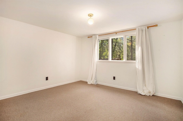 unfurnished room featuring carpet flooring and baseboards