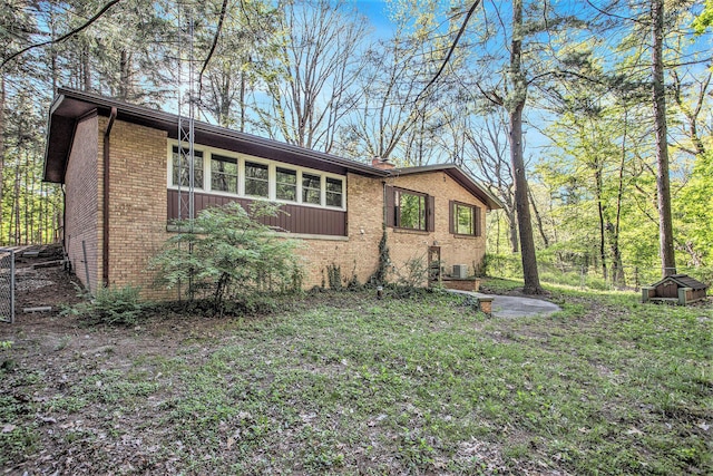 view of property exterior featuring brick siding and central AC unit