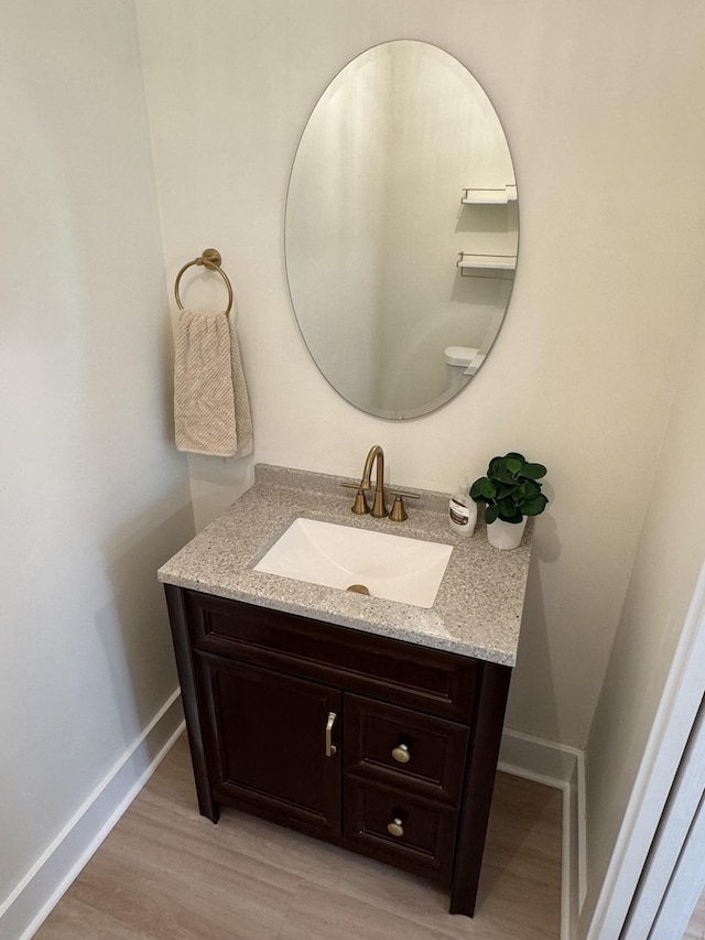 928 Lincoln St, Grand Rapids, MI 49534 - bathroom with vanity, baseboards, and wood finished floors