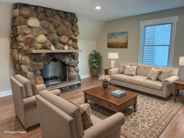 928 Lincoln St, Grand Rapids, MI 49534 - living room featuring baseboards, wood finished floors, a stone fireplace, lofted ceiling, and recessed lighting