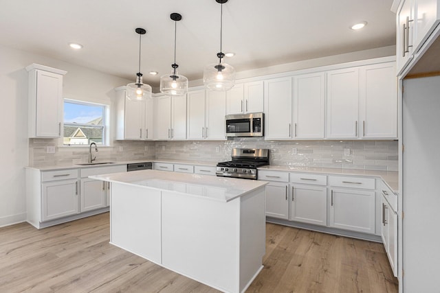 6182 Longhorn Trl, Stevensville, MI 49127 - kitchen with appliances with stainless steel finishes, light wood-style floors, light countertops, white cabinetry, and backsplash