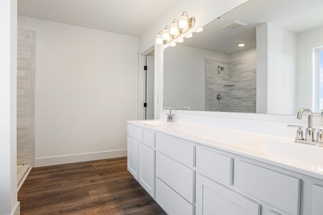 6182 Longhorn Trl, Stevensville, MI 49127 - bathroom featuring double vanity, wood finished floors, tiled shower, and recessed lighting