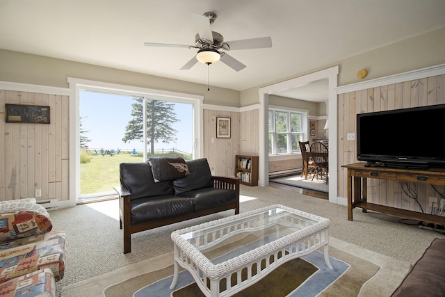 2177 S Lakeshore Dr, Ludington, MI 49431 - living room with light colored carpet, wood walls, ceiling fan, and a baseboard heating unit