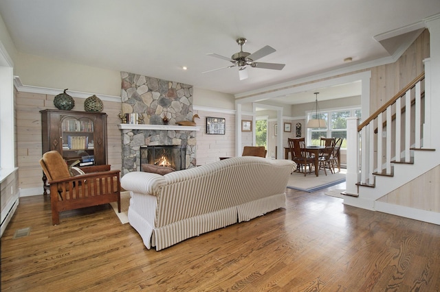 2177 S Lakeshore Dr, Ludington, MI 49431 - living area with a fireplace, wood finished floors, ceiling fan, stairs, and wood walls