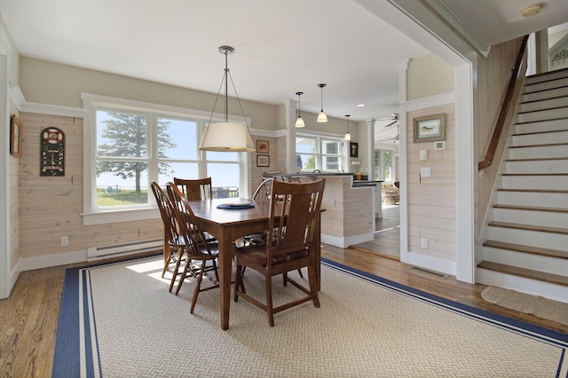 2177 S Lakeshore Dr, Ludington, MI 49431 - dining room featuring light wood-style flooring, wooden walls, stairs, baseboard heating, and recessed lighting