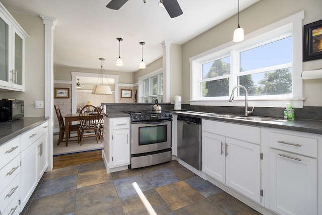 2177 S Lakeshore Dr, Ludington, MI 49431 - kitchen with stainless steel appliances, a sink, dark countertops, ceiling fan, and a peninsula