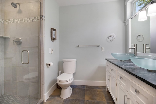 2177 S Lakeshore Dr, Ludington, MI 49431 - bathroom featuring double vanity, toilet, a shower stall, and baseboards