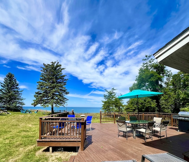 2177 S Lakeshore Dr, Ludington, MI 49431 - wooden terrace with outdoor dining area, a yard, a water view, and grilling area