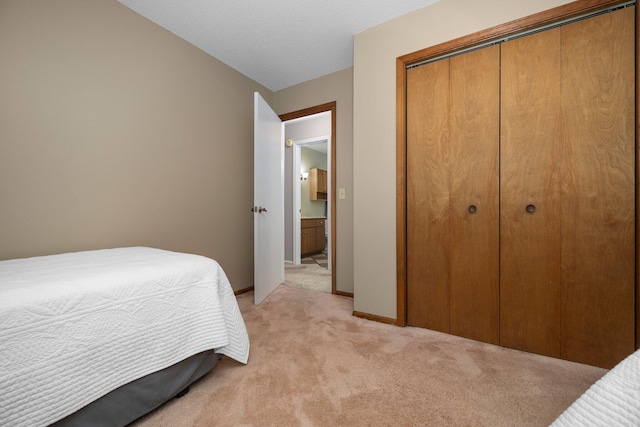 bedroom with light carpet, a closet, and baseboards
