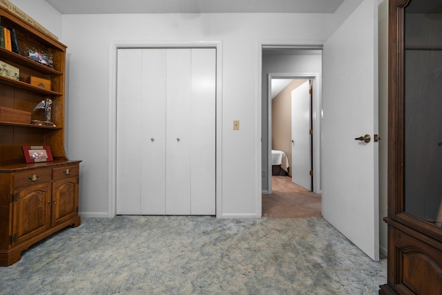 carpeted bedroom featuring a closet and baseboards