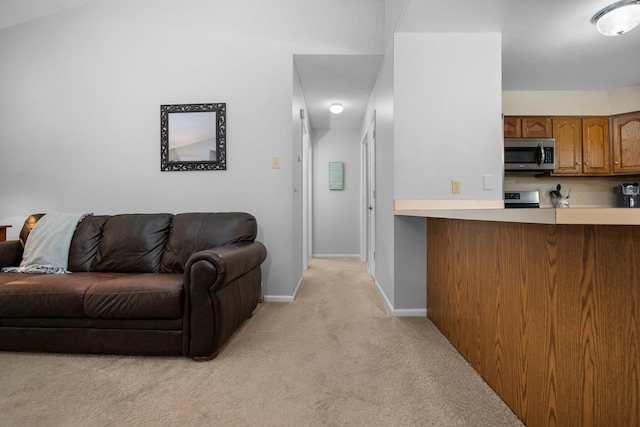 living area with light colored carpet and baseboards