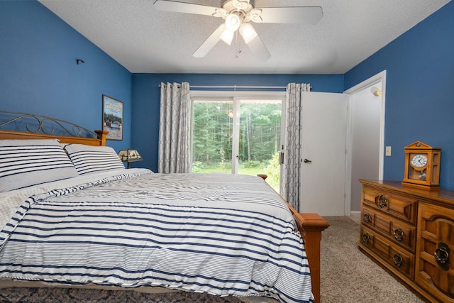 carpeted bedroom with access to outside, a textured ceiling, and a ceiling fan