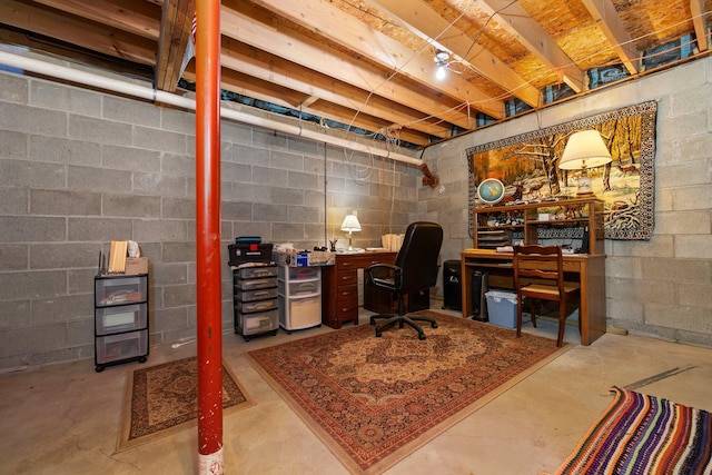 office space with concrete flooring and concrete block wall