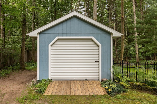 view of shed featuring fence and a view of trees