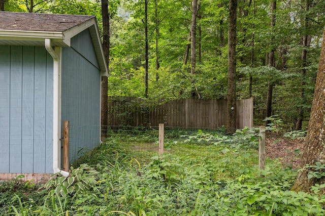 view of yard featuring fence and a forest view