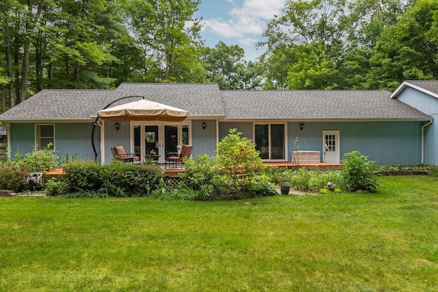 view of front of home featuring a front yard and a shingled roof