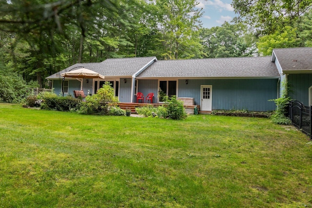 ranch-style home with a front lawn and roof with shingles