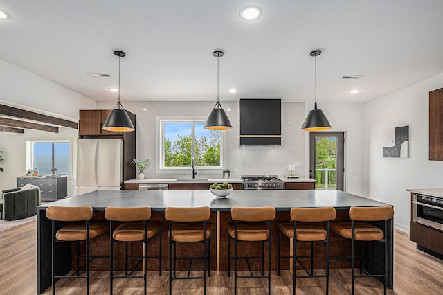 3500 Lakeshore Dr, Saint Joseph, MI 49085 - kitchen featuring freestanding refrigerator, a sink, extractor fan, light wood finished floors, and tasteful backsplash
