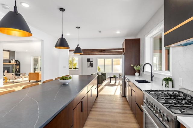 3500 Lakeshore Dr, Saint Joseph, MI 49085 - kitchen featuring gas range, a sink, light wood-style floors, recessed lighting, and decorative light fixtures
